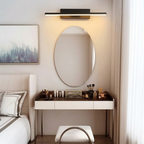 Applique murale orientable en aluminium noir installée au-dessus d'un lit